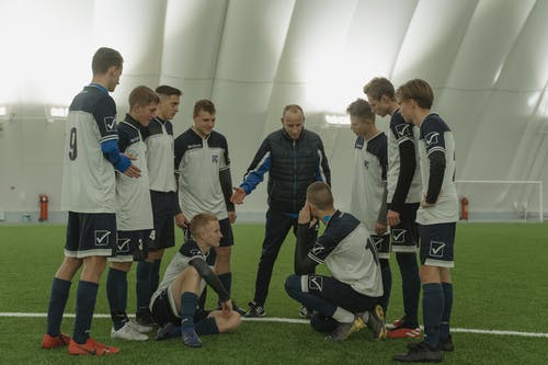 Players and coach amidst a huddle