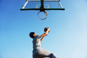 A basketball player dunking the ball in the basket