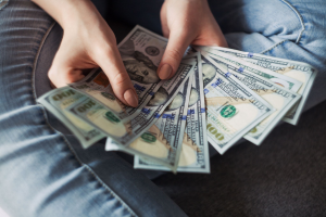 A person holding $100 banknotes