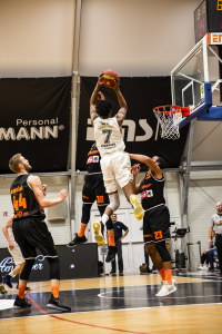 Two basketball teams in mid-air during a dunk