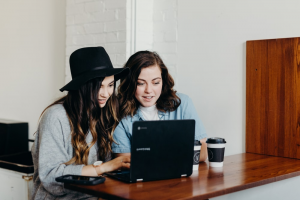Two girls browsing on a laptop together