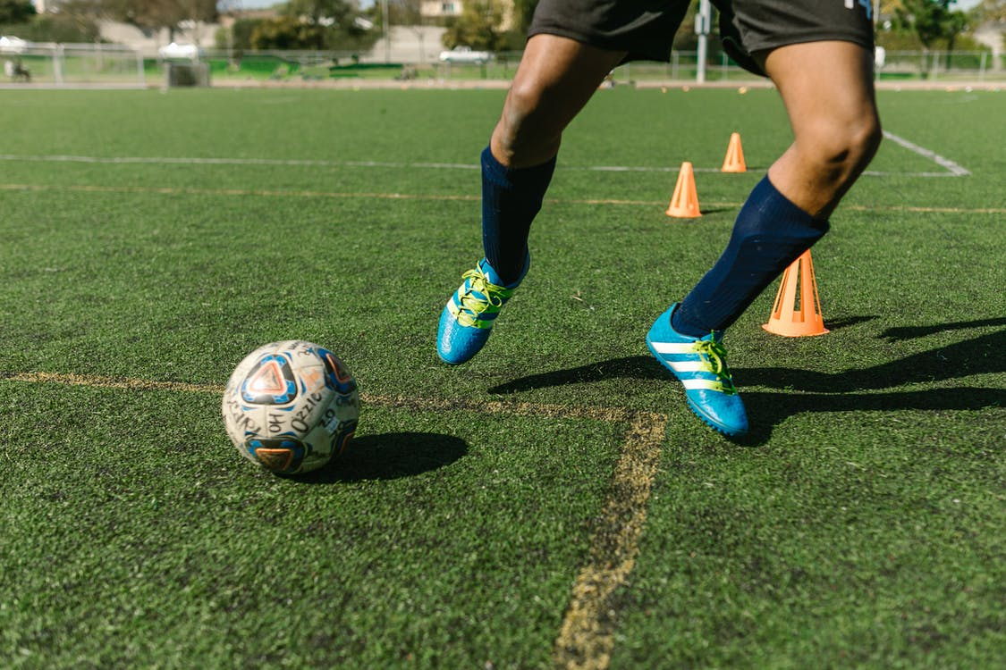 A cutoff shot of a football player kicking the football around