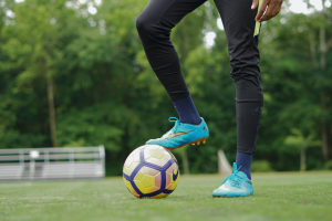 A football player standing with their right foot on a football