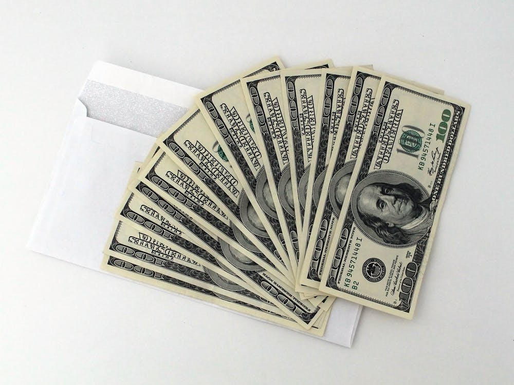Money won through online gambling placed on top of a white envelope