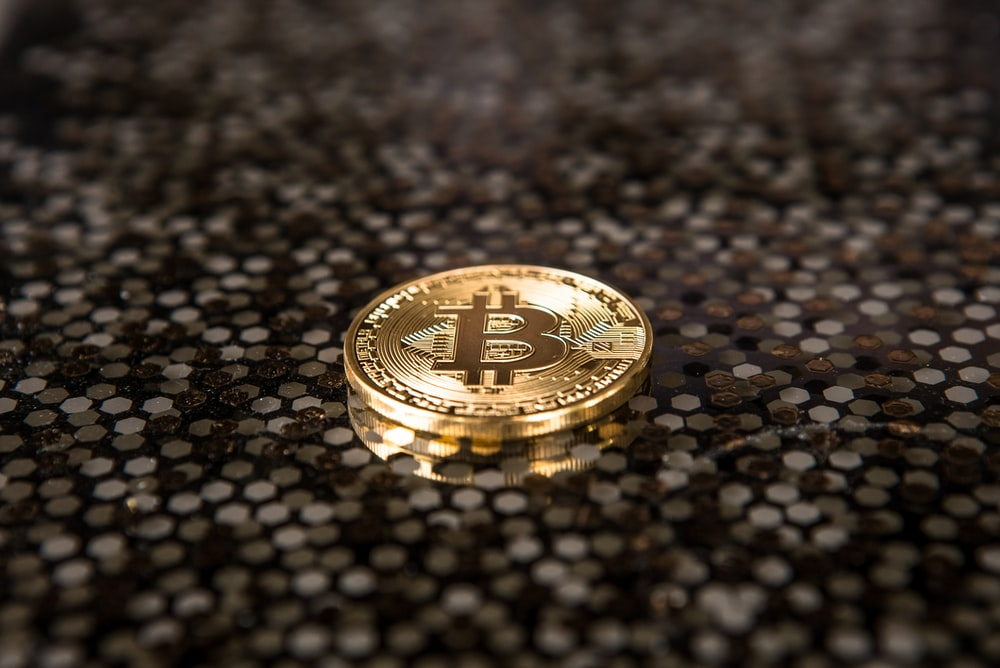 A gold-colored coin with a Bitcoin sign