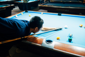 Man in blue shirt playing a game of snooker