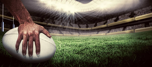 A player’s hands on the ball in an empty stadium