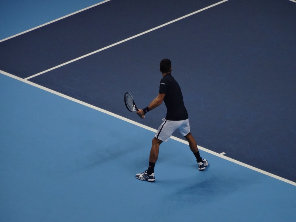 A man playing tennis holding a black racket