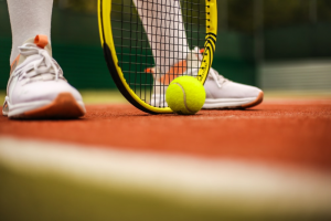 Player holding tennis racket by their feet