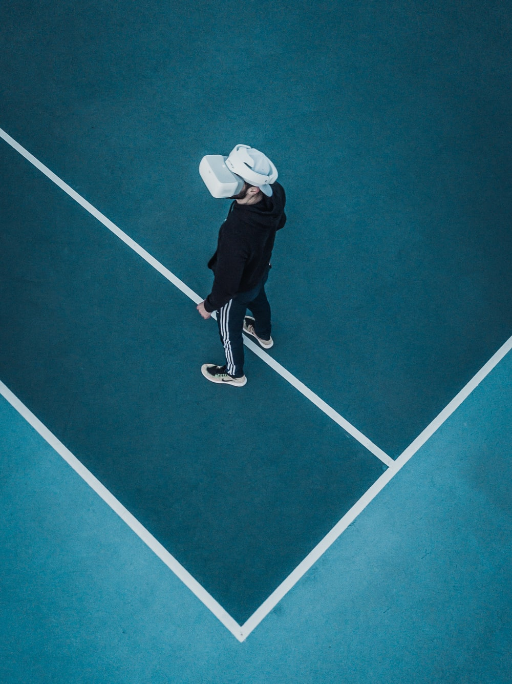 A sports bettor wearing a VR headset on a tennis court
