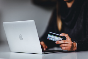 A woman holding her credit card to deposit money on an online betting site