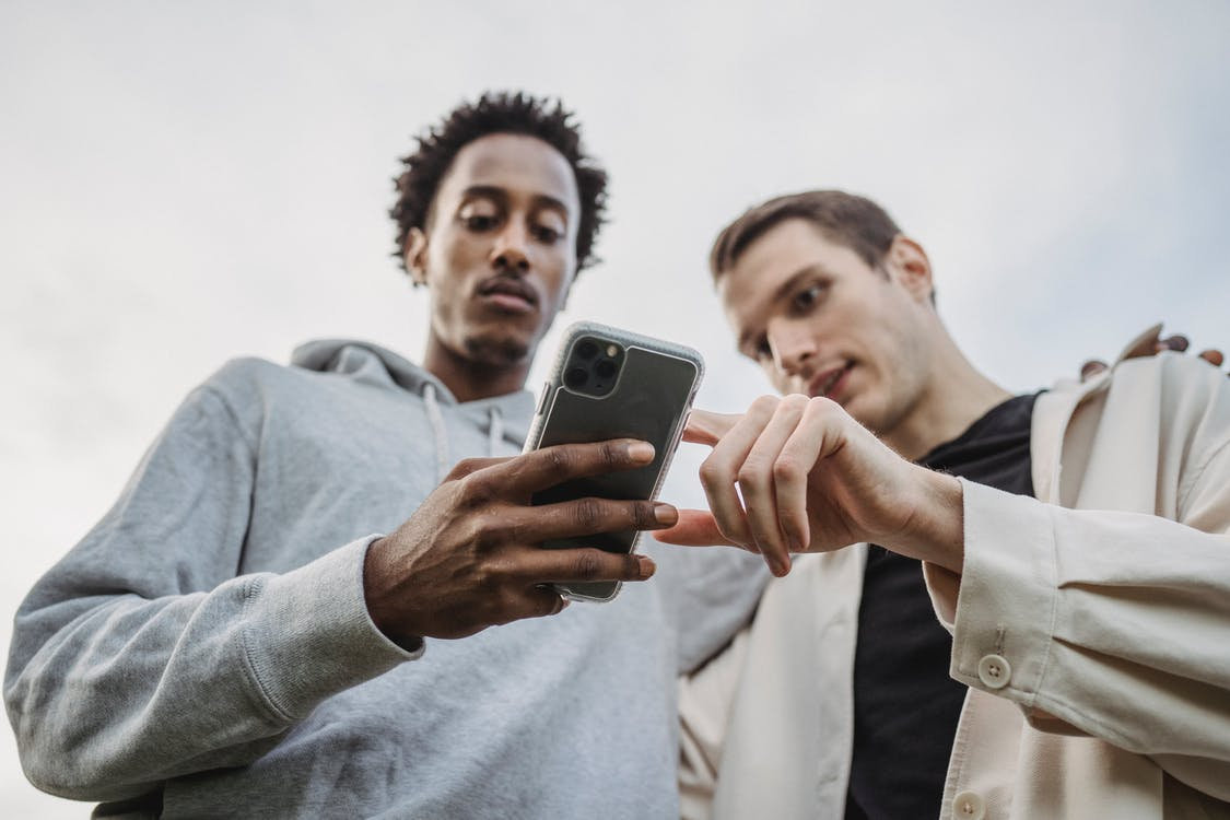 Multiethnic men browsing a smartphone together