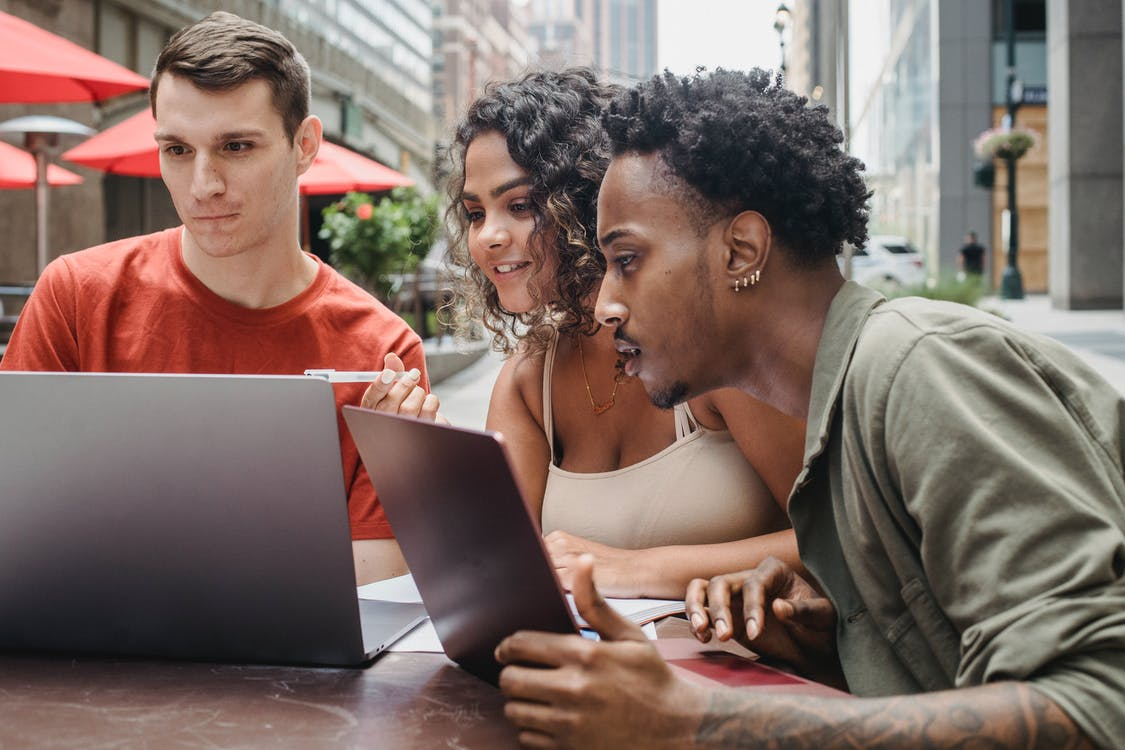 Multi-racial persons looking at a laptop