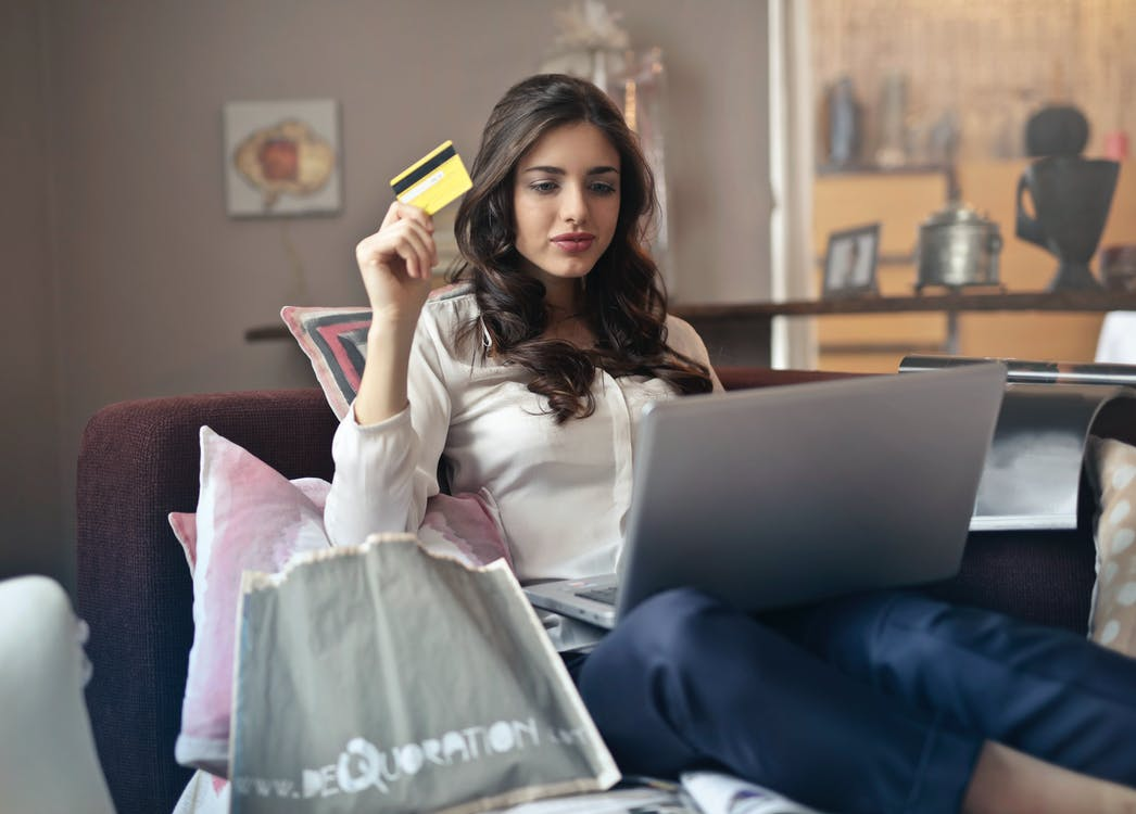 A woman using her laptop while holding a credit card
