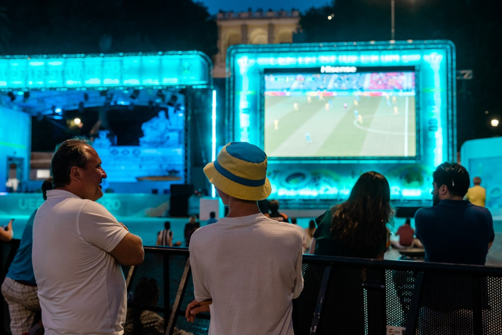 People watching football at an outdoor viewing station