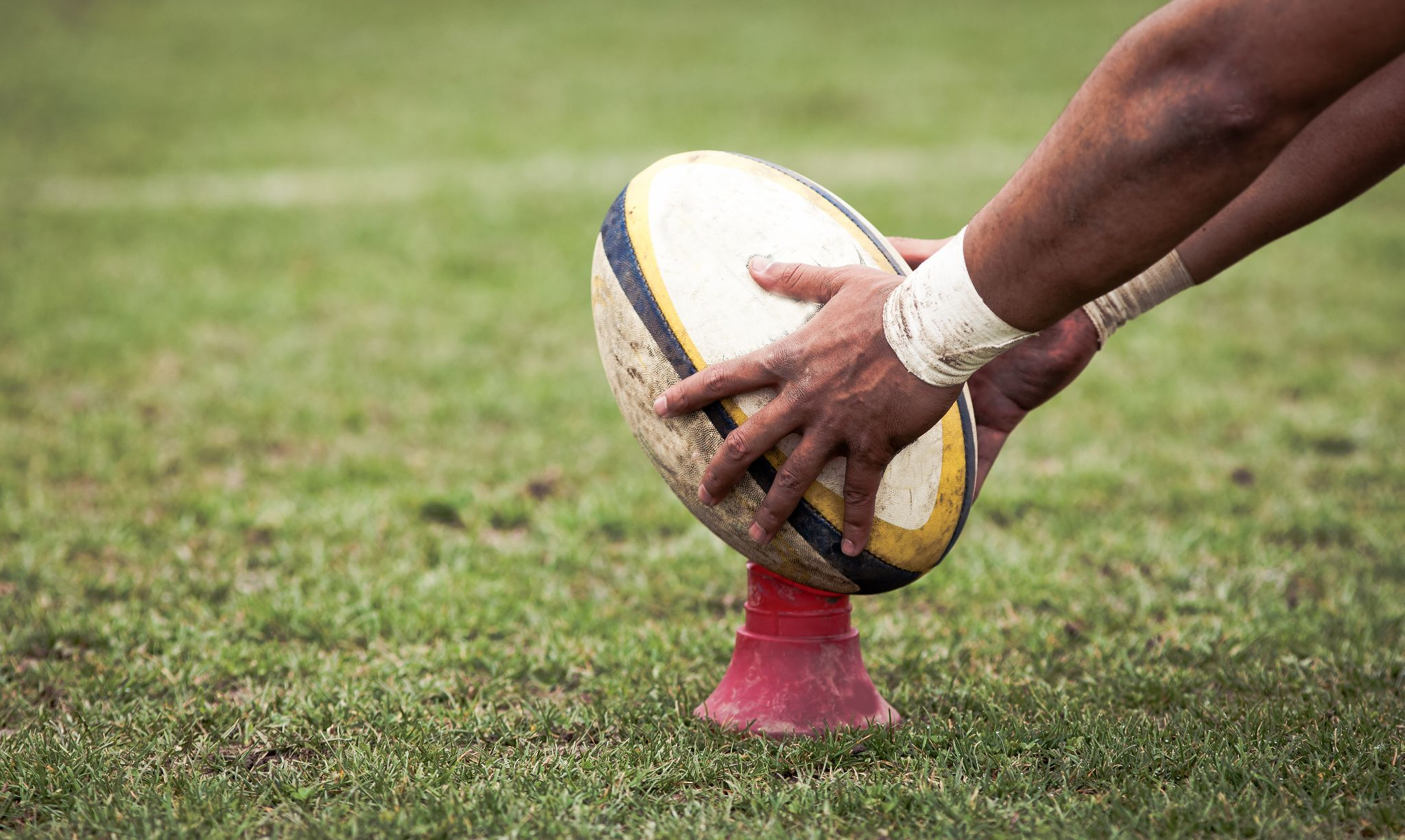 A rugby player picking up the rugby ball