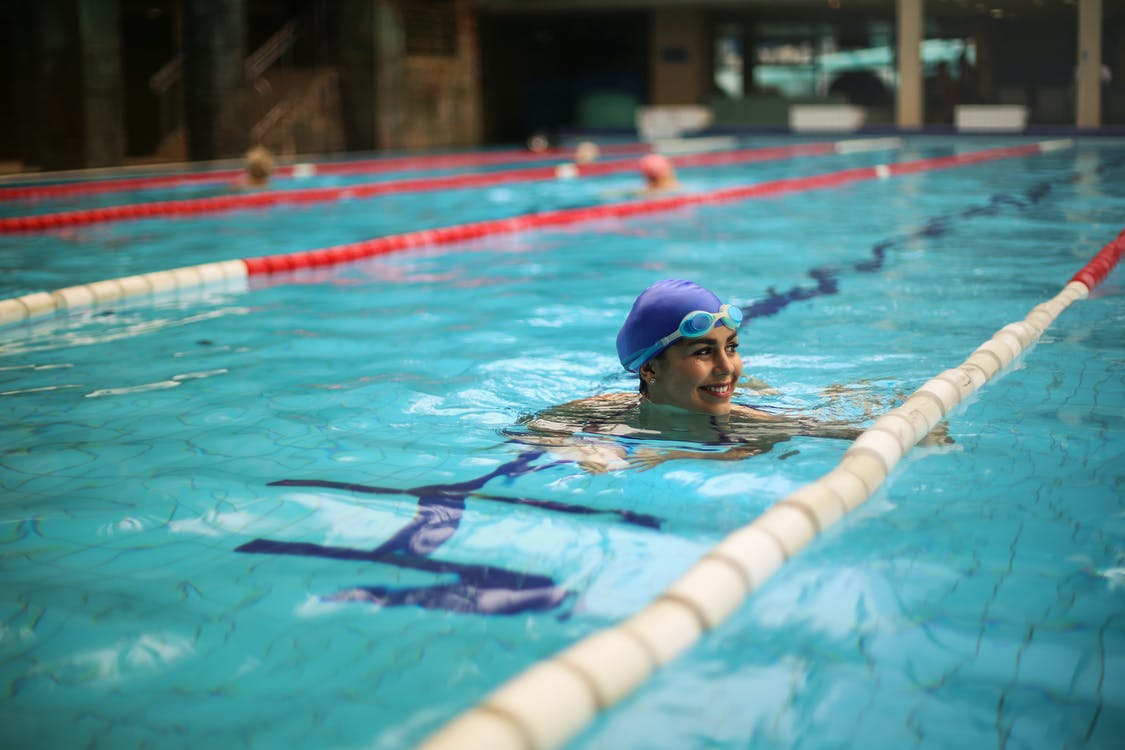 A competitive female swimmer smiling in the water