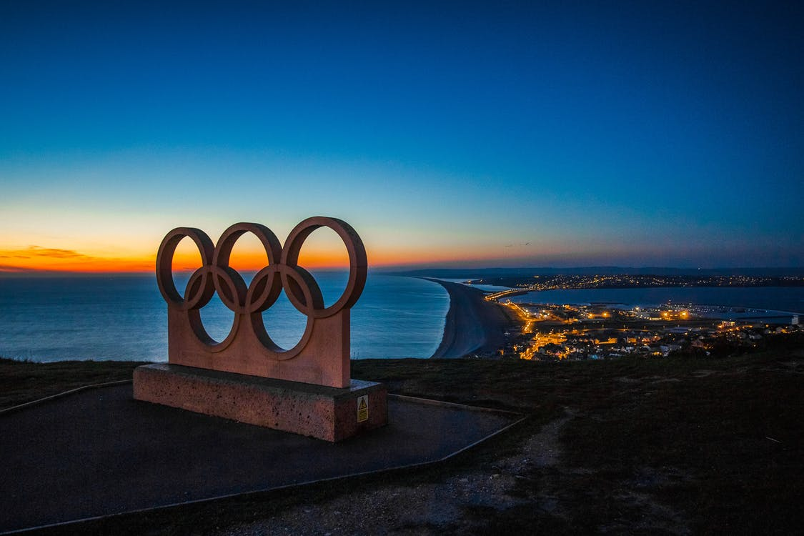 An Olympics ring monument overlooking the ocean at sunset