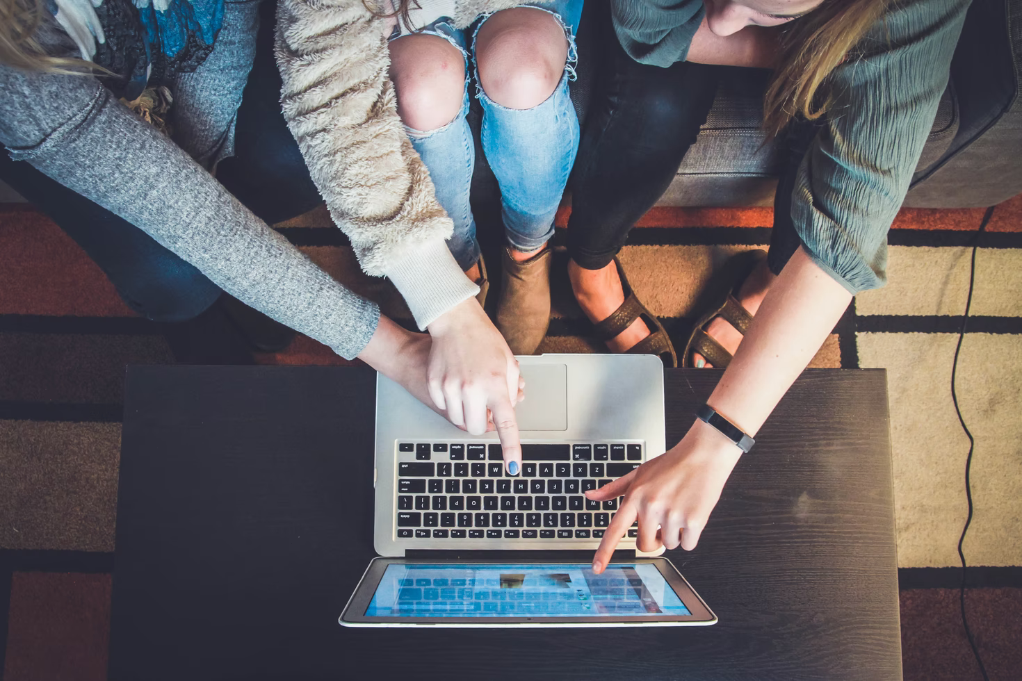 A group of friends watching a sporting event on a laptop