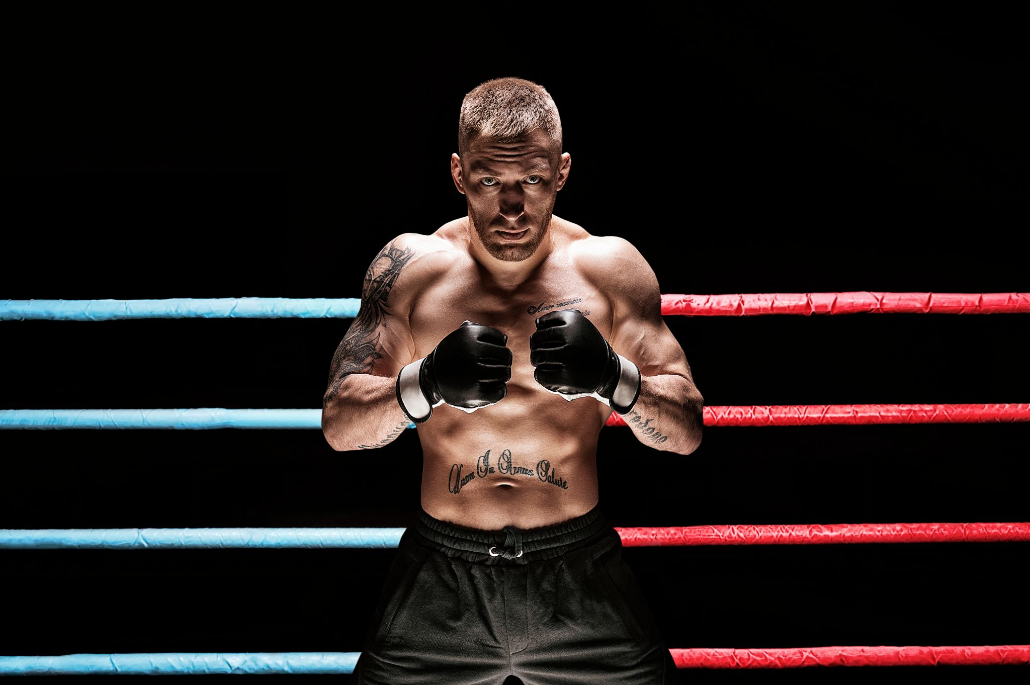 A man posing in front of the boxing ring