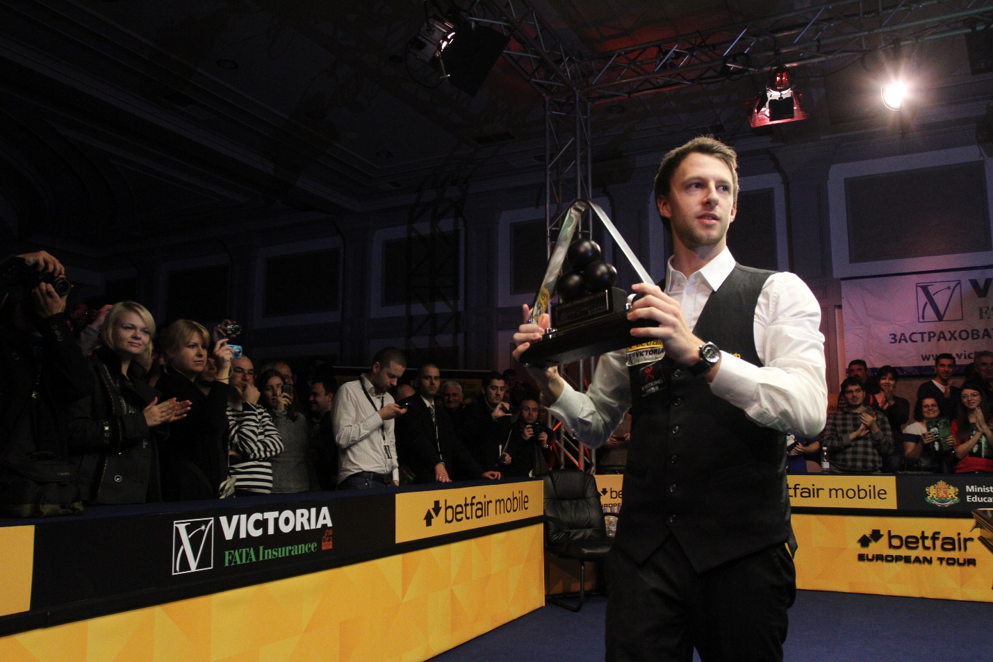 A snooker player holding his trophy