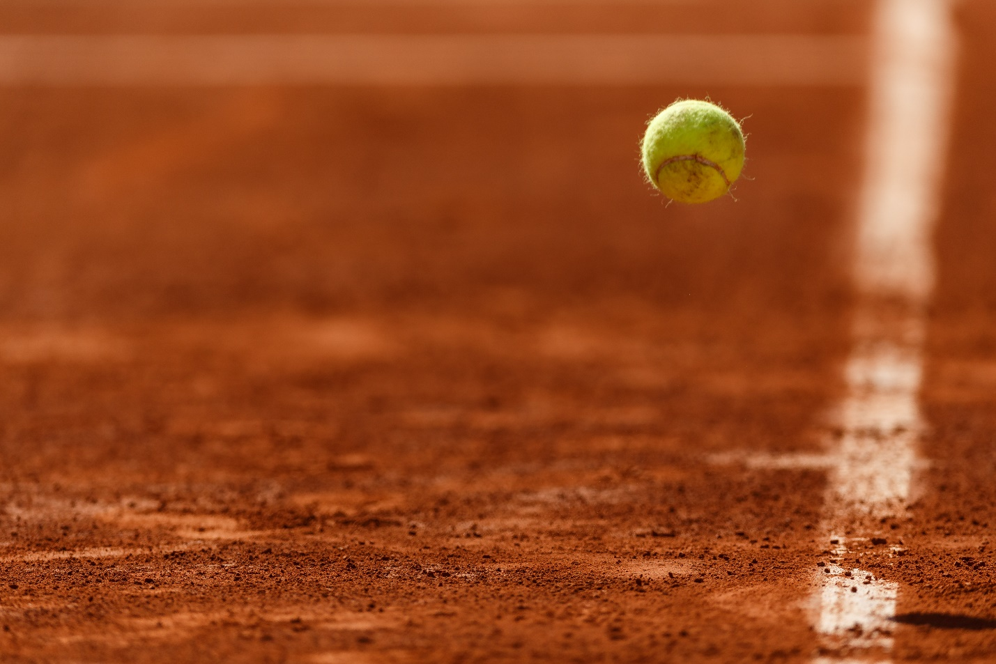 A tennis ball bouncing on a clay court