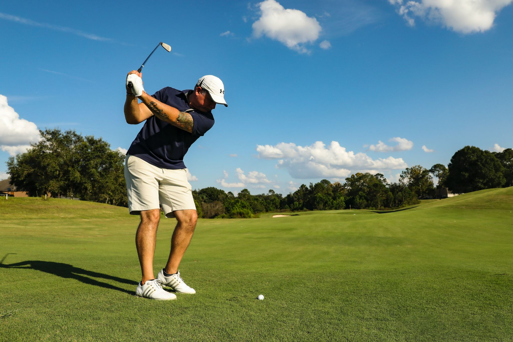 A man playing golf under the blue skies