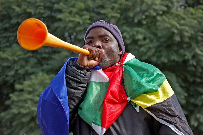 An African football fan blowing a horn