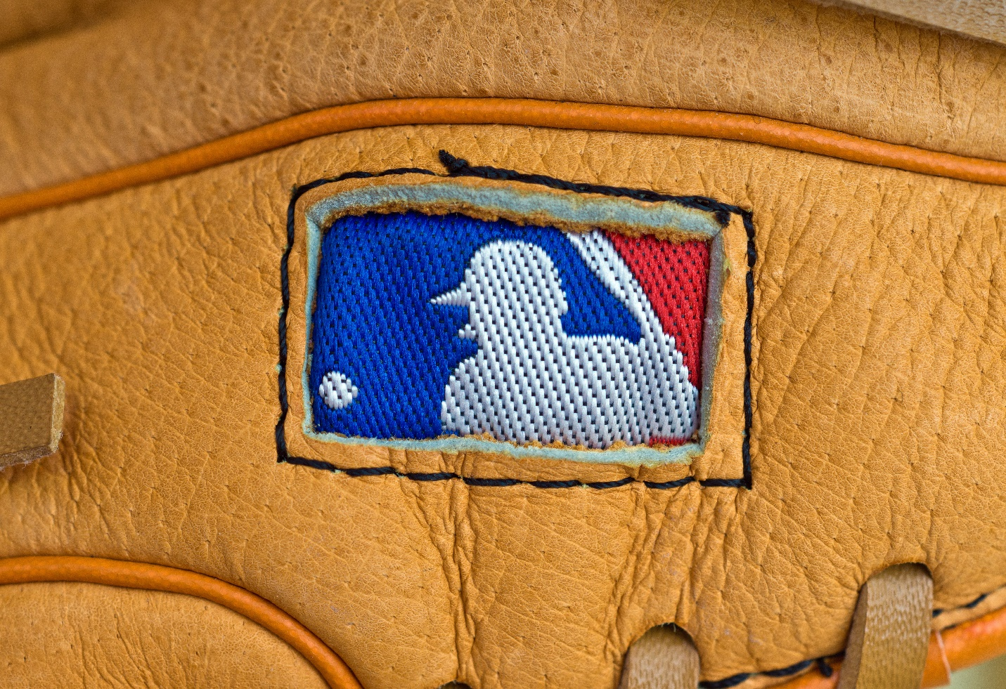 The MLB logo printed on a leather glove