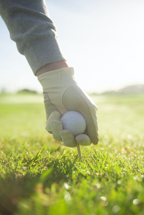  A gloved hand holding a golf ball