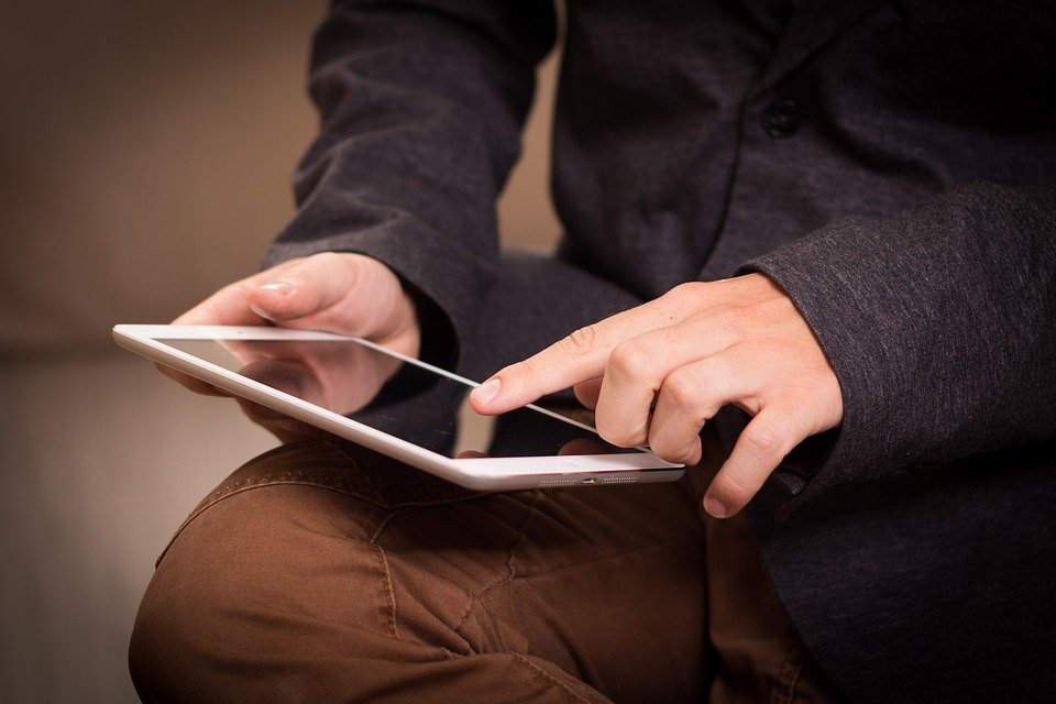 A man using a betting app on his tablet