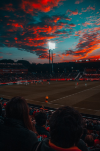 a soccer field under red sky