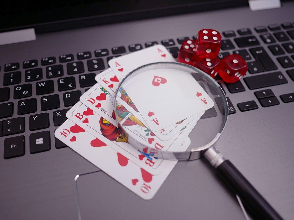 Cards and magnifying glass placed on top of a laptop