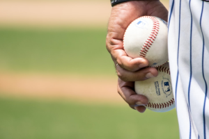 A baseball player holding a couple of baseballs