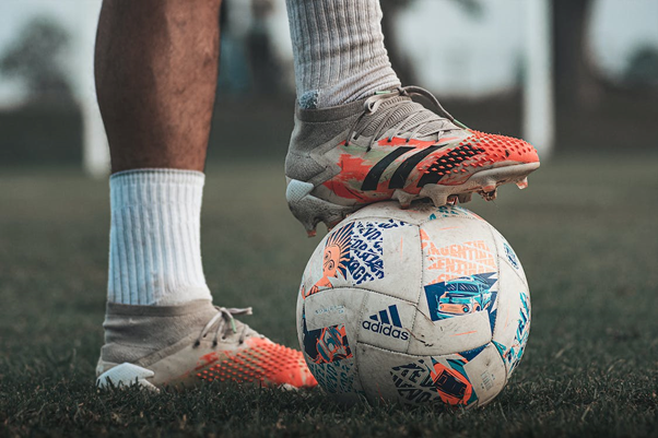 a football player’s boots on a ball