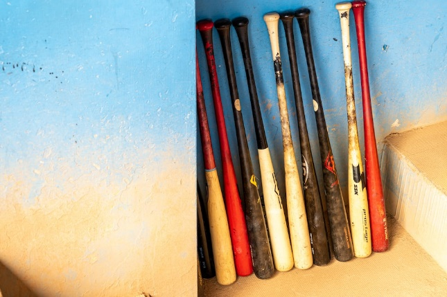 Baseball bats stacked against a wall