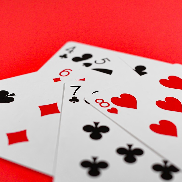 Several playing cards on a red table