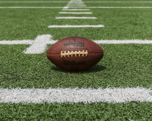 An American football on a grassy surface