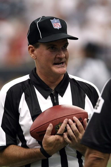 An NFL match umpire holding a ball