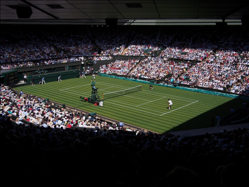 A big tennis game taking place with a packed crowd