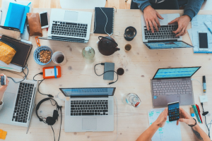 People using computers and phones at a table