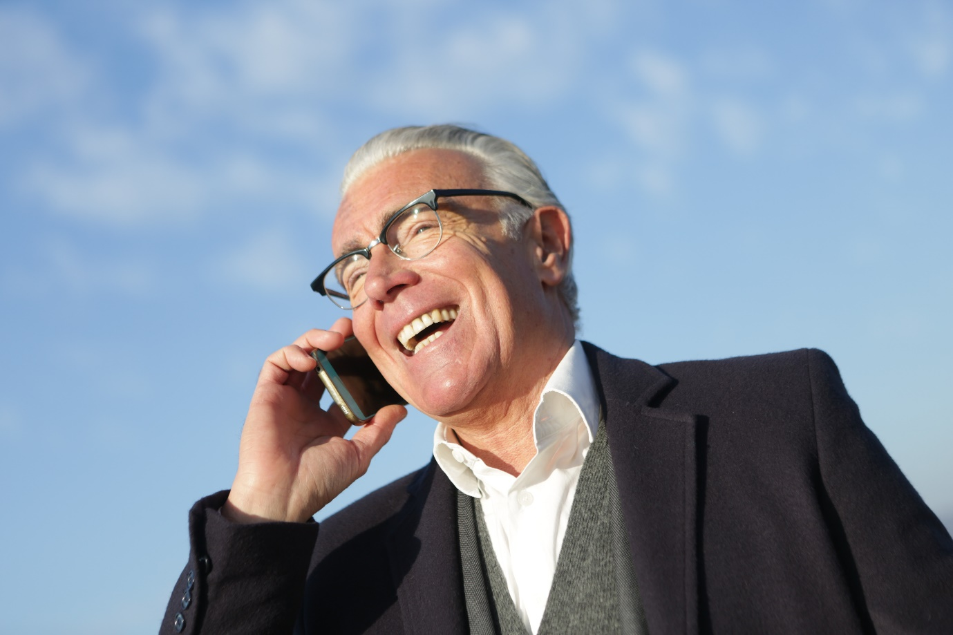 a senior businessman talking on a smartphone on the street